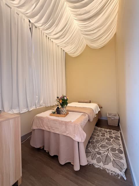 Treatment bed beside a curtained window at Havenly Wellness & Head Spa